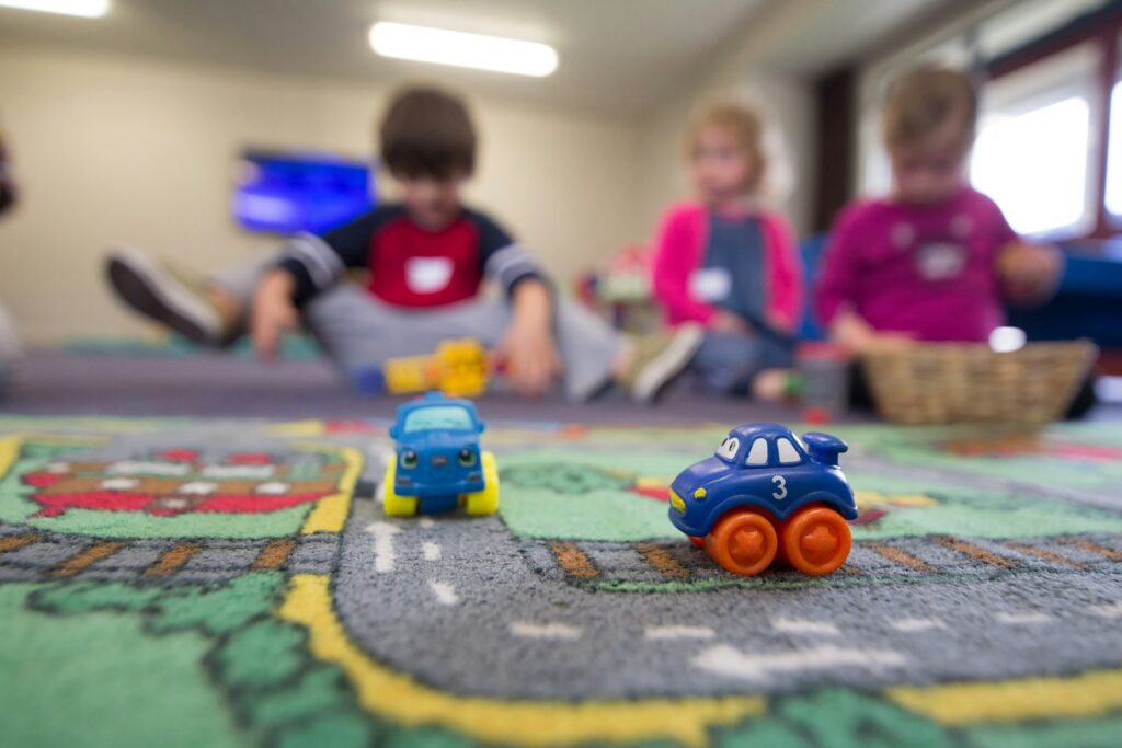 A group of children playing with toys on the floor