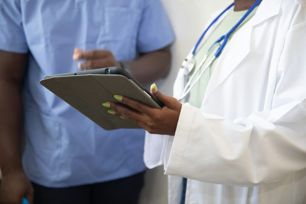 Doctor shows nurse something on a mobile tablet device.